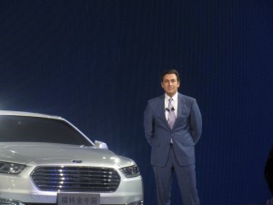 Ford Motor Company Chief Executive Officer Mark Fields standing next to the China-exclusive Ford Taurus.