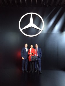 LIASE Group Managing Director for the Americas John Bukowicz (left), LIASE Group Managing Director Asia Vanessa Moriel (center) and LIASE Group President and Managing Director Europe Wolfgang Doell (right) standing in front of the Mercedes-Benz logo at the Frankfurt Motor Show.  